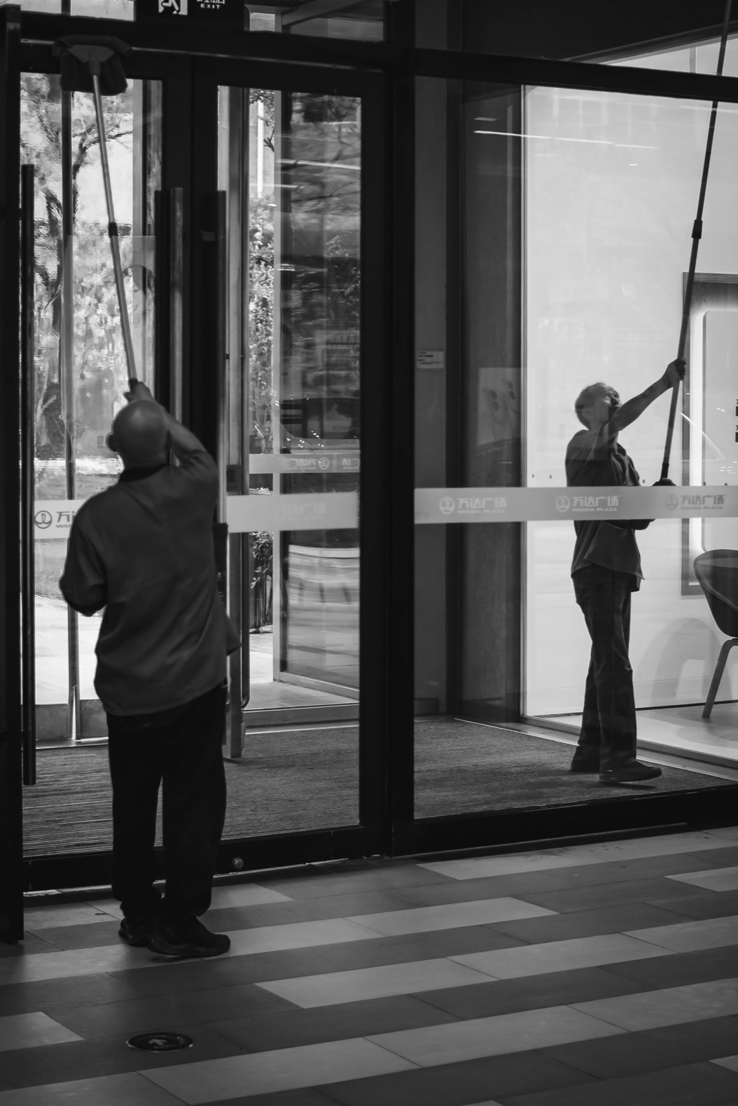 Professionnels de la propreté intervenant sur les vitrages d’un bâtiment contemporain
